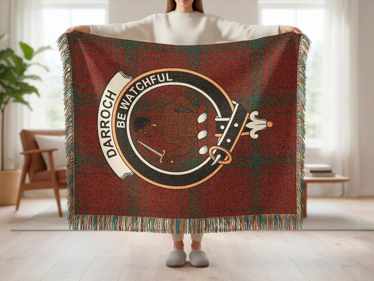Person holding the Darroch woven blanket to show the full design, tartan background and fringe