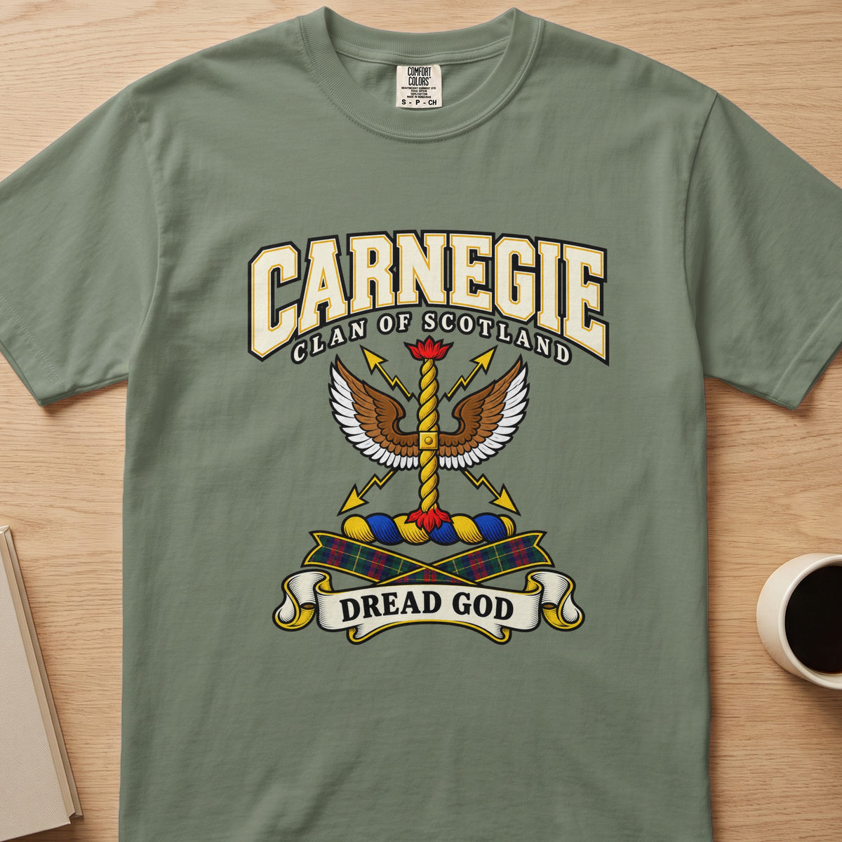 Carnegie spread-wing crest and gold detail graphic on a sage green Comfort Colors T-shirt, front view