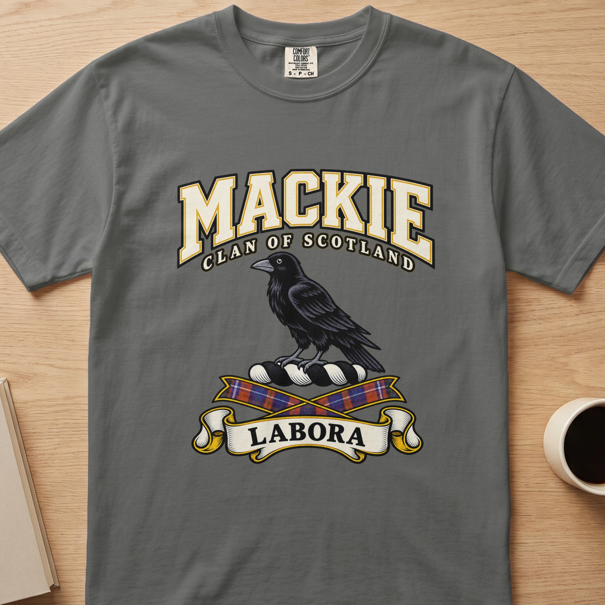 MacKie clan T-shirt in gray, front view with black bird above tartan ribbons
