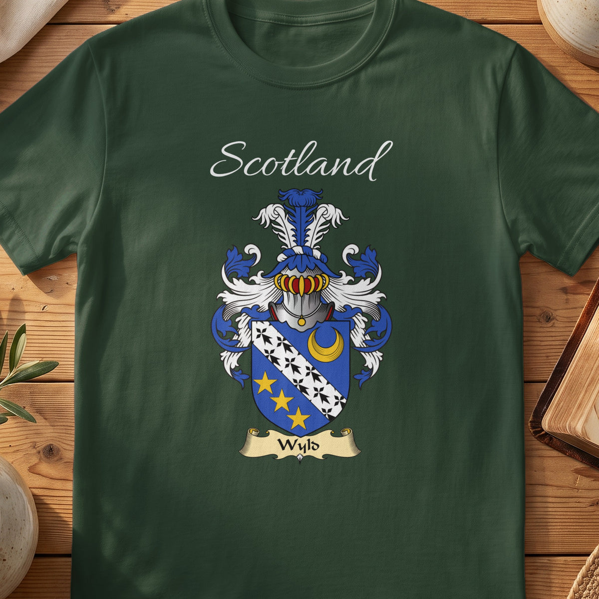 Forest Green Wyld Scottish T-shirt laid flat with coat of arms artwork and “Scotland” text.