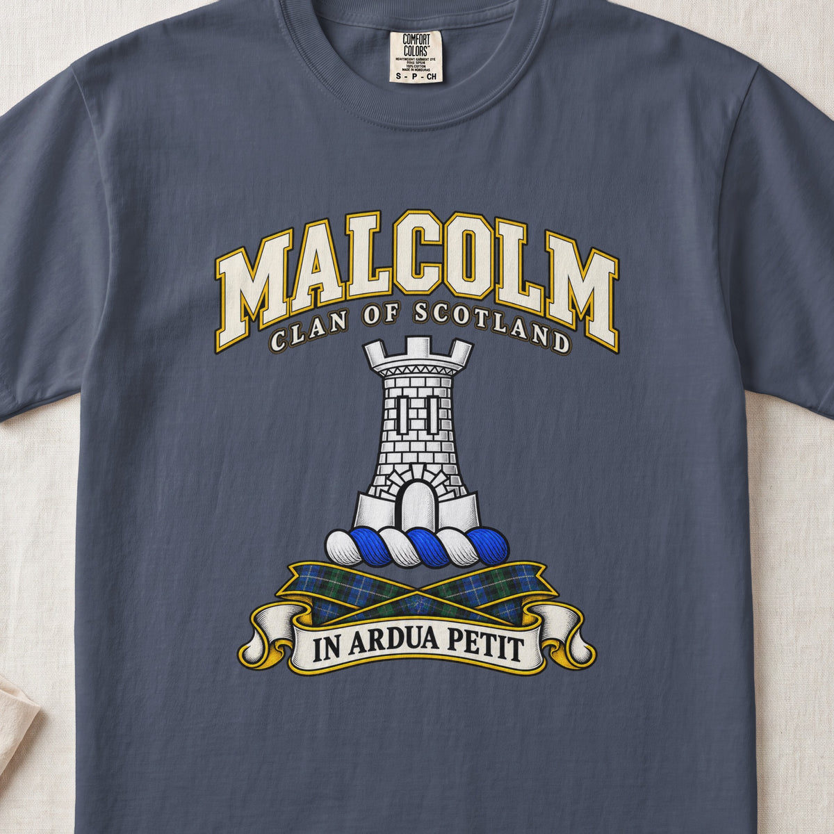 Malcolm Scottish clan T-shirt in Midnight, front view with a gray stone tower and motto banner.