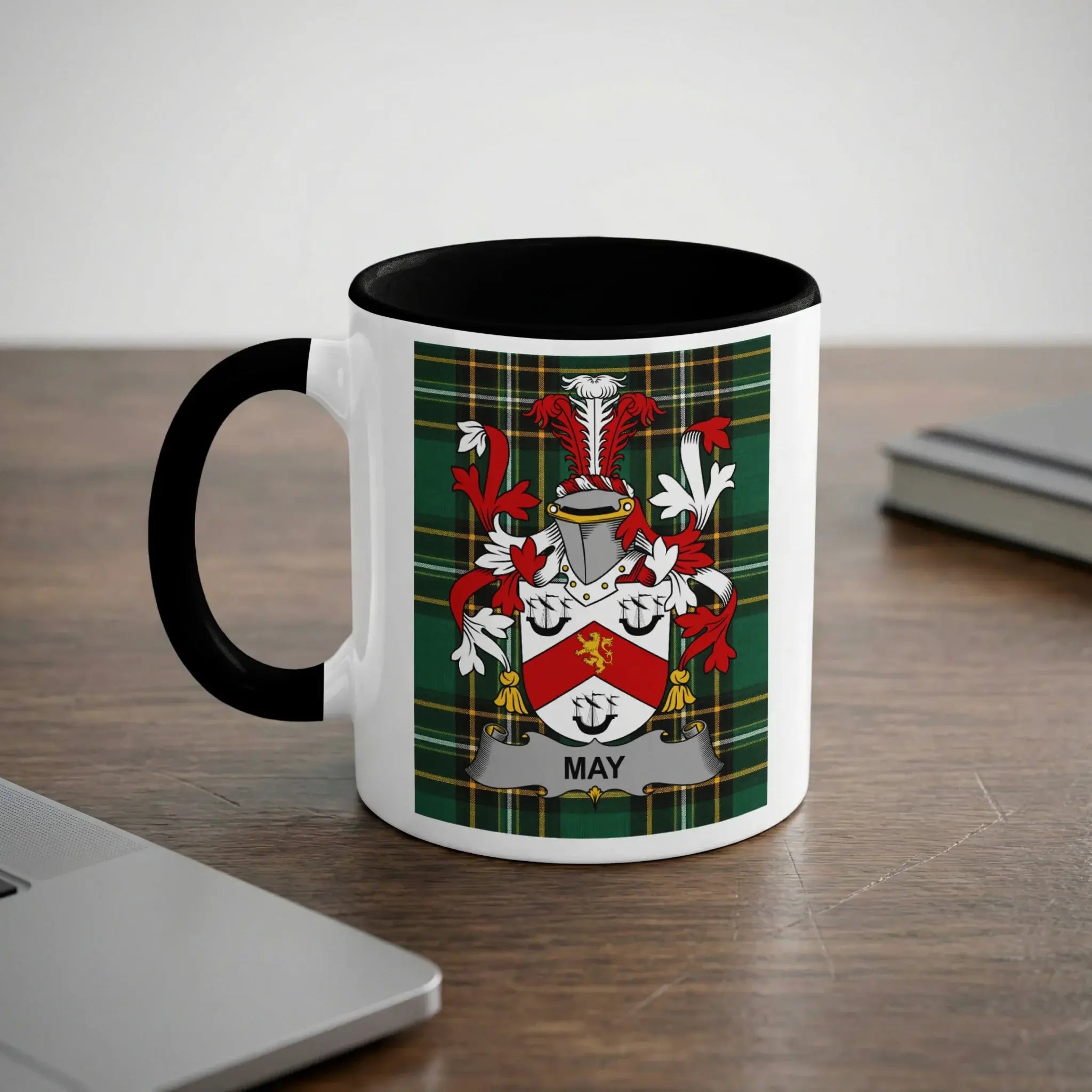 White mug with black handle featuring a green tartan shield with "MAY" text.