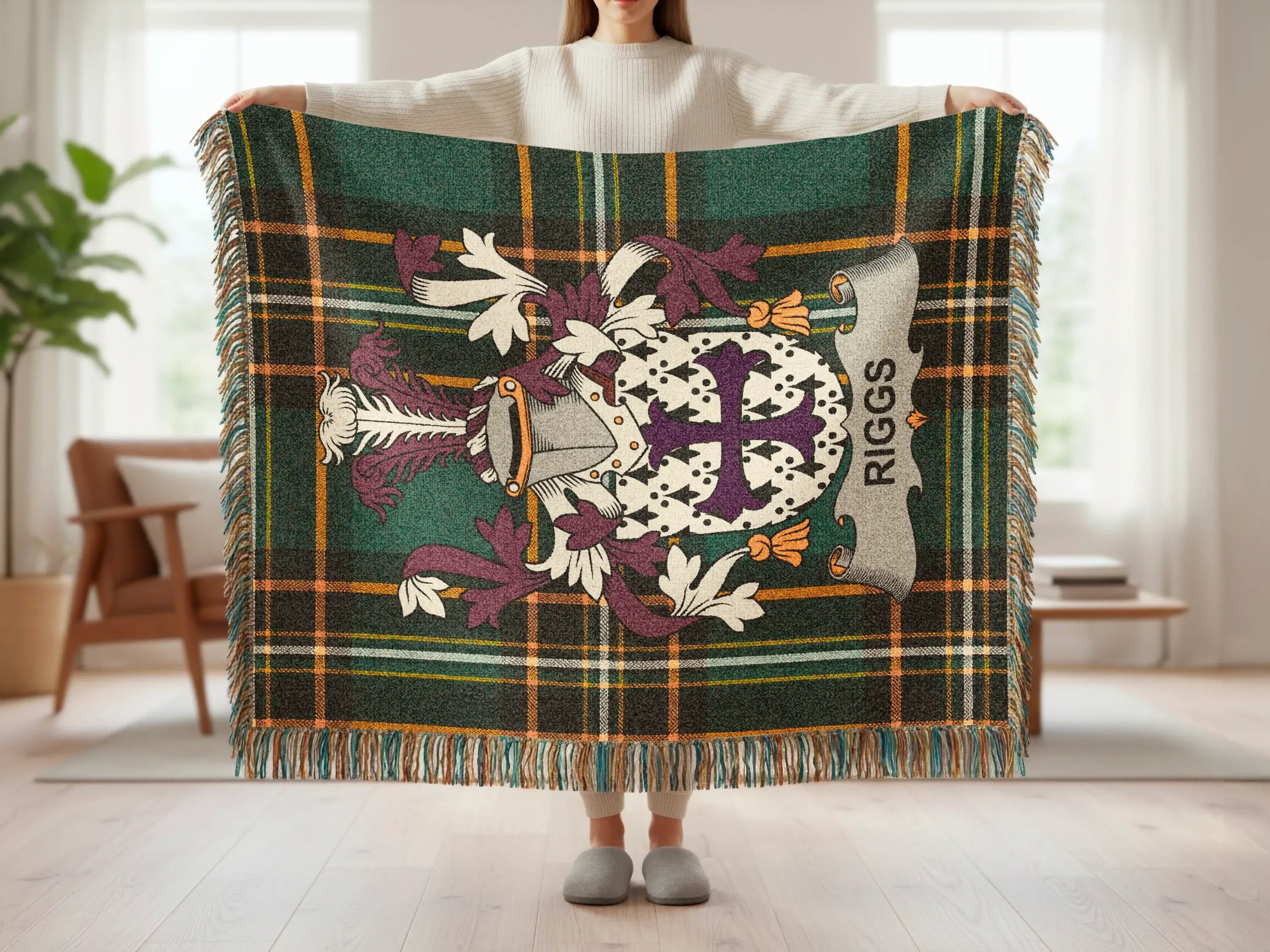 Tartan blanket with "RIGGS" banner and heraldic crest, held by a person.