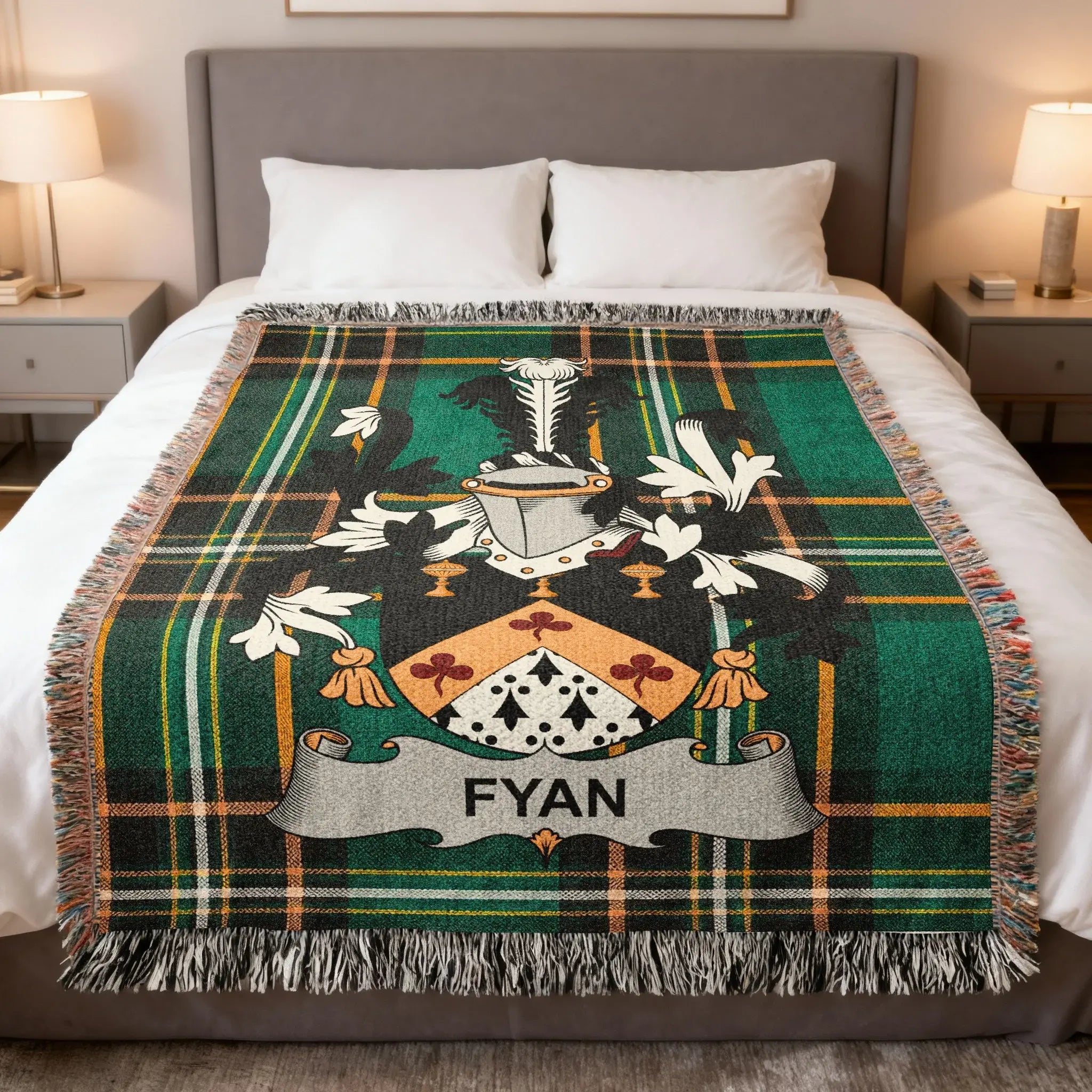 Green tartan blanket draped on a bed with a coat of arms featuring the name FYAN.