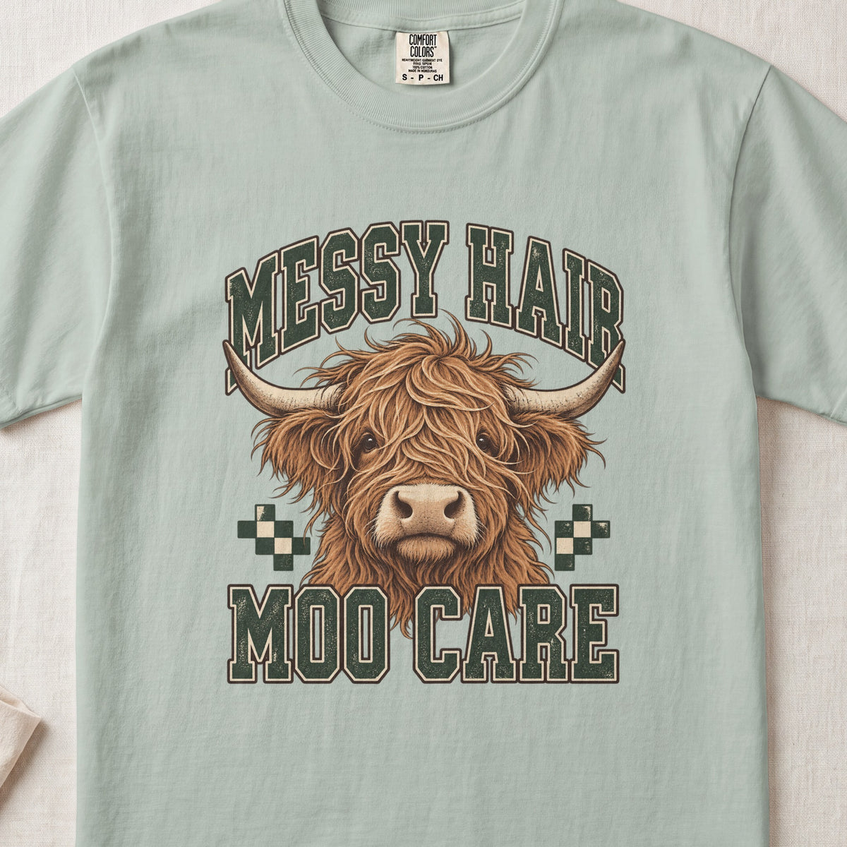 Messy Hair, Moo Care Highland cow design on a Bay Comfort Colors 1717 T-shirt, flat lay