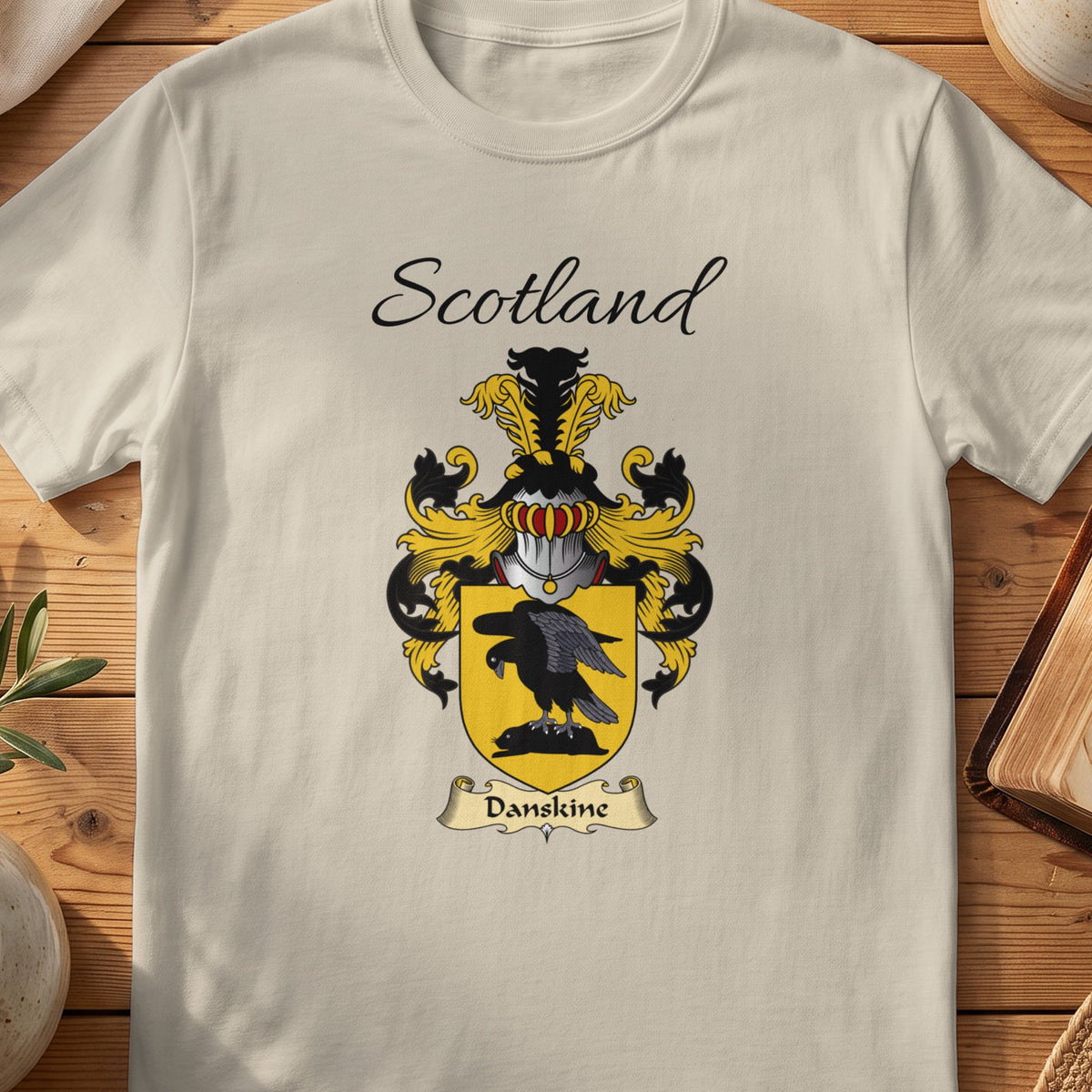 Sand Danskine Scottish family shield T-shirt featuring a black bird on a gold shield