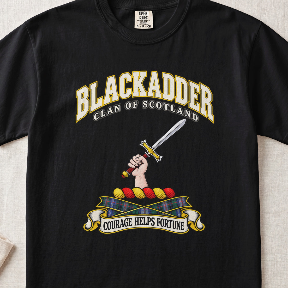 Blackadder Scottish clan T-shirt in Black, front view with a hand holding a raised sword and motto banner.