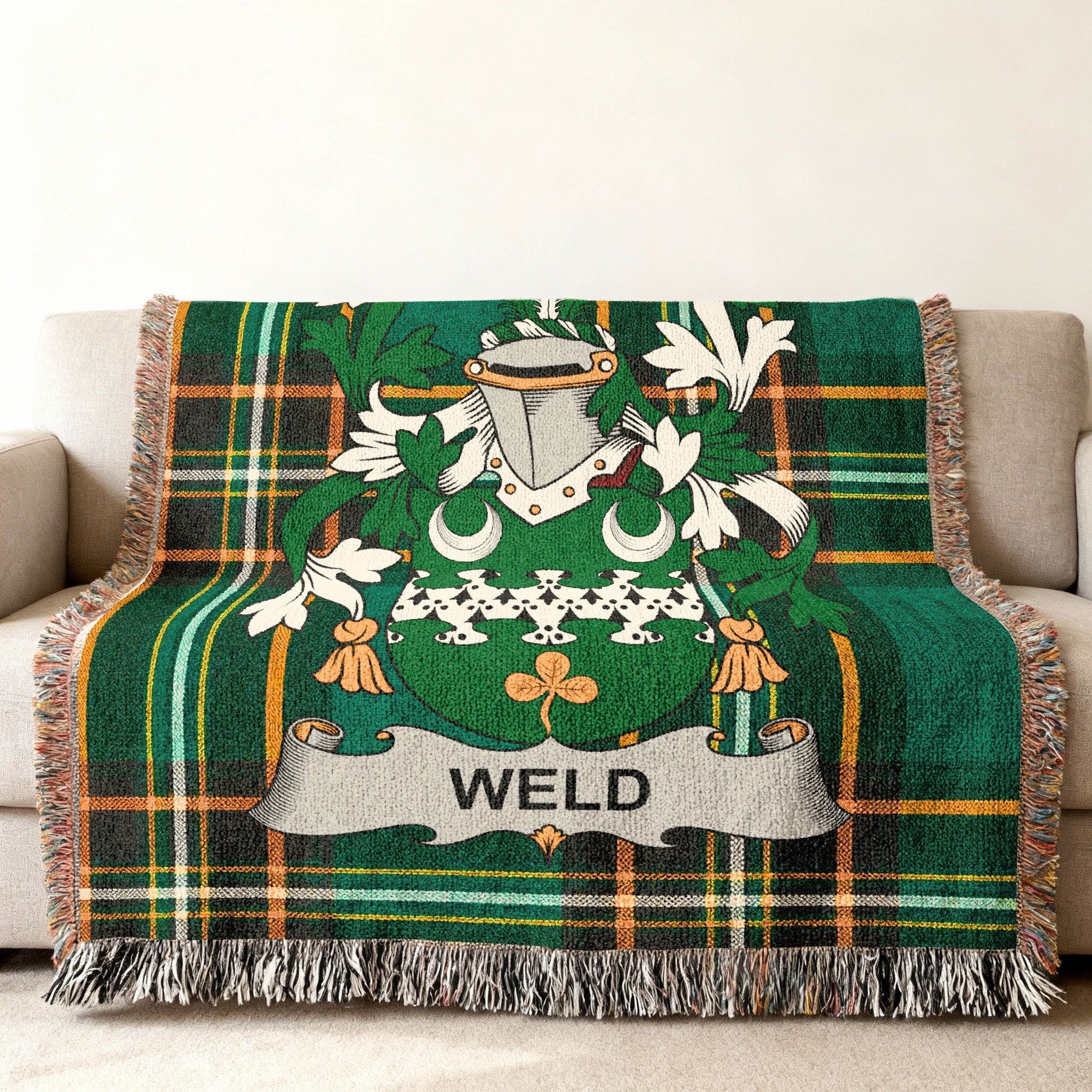 Woven blanket with a green plaid pattern and the Weld family crest.