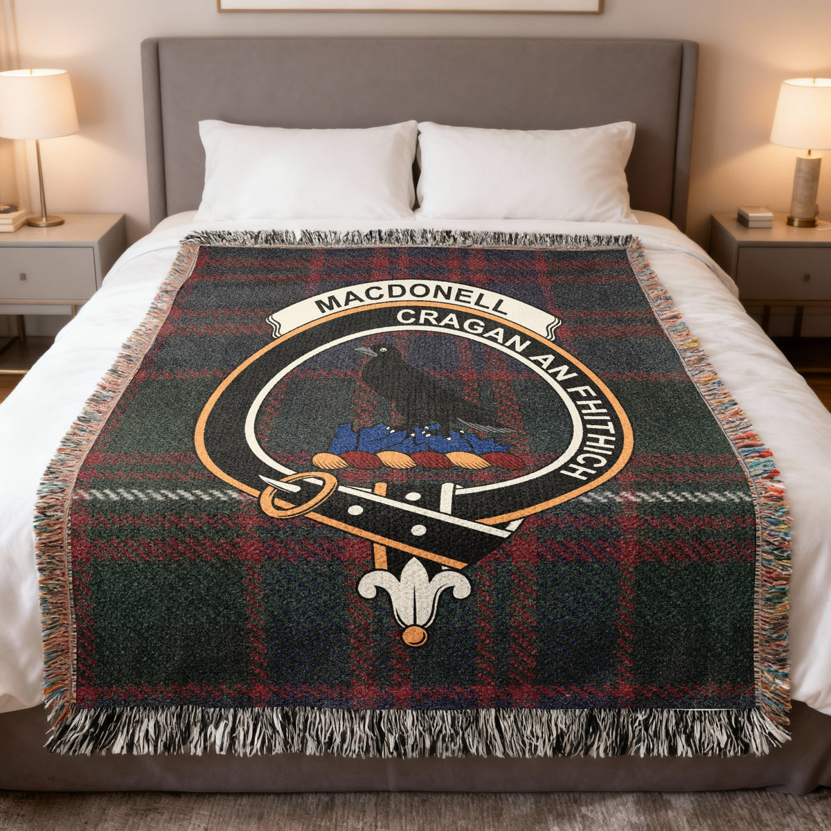 MacDonell of Glengarry woven blanket displayed on a bed, with a raven on a rock on a red and dark green tartan background