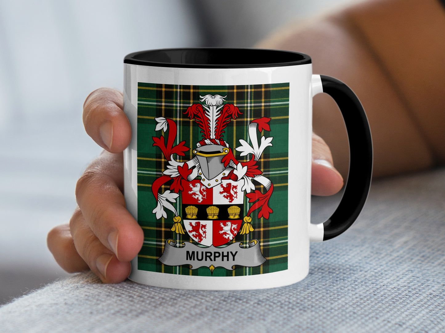White mug with black handle displaying the Murphy family crest on a tartan background.