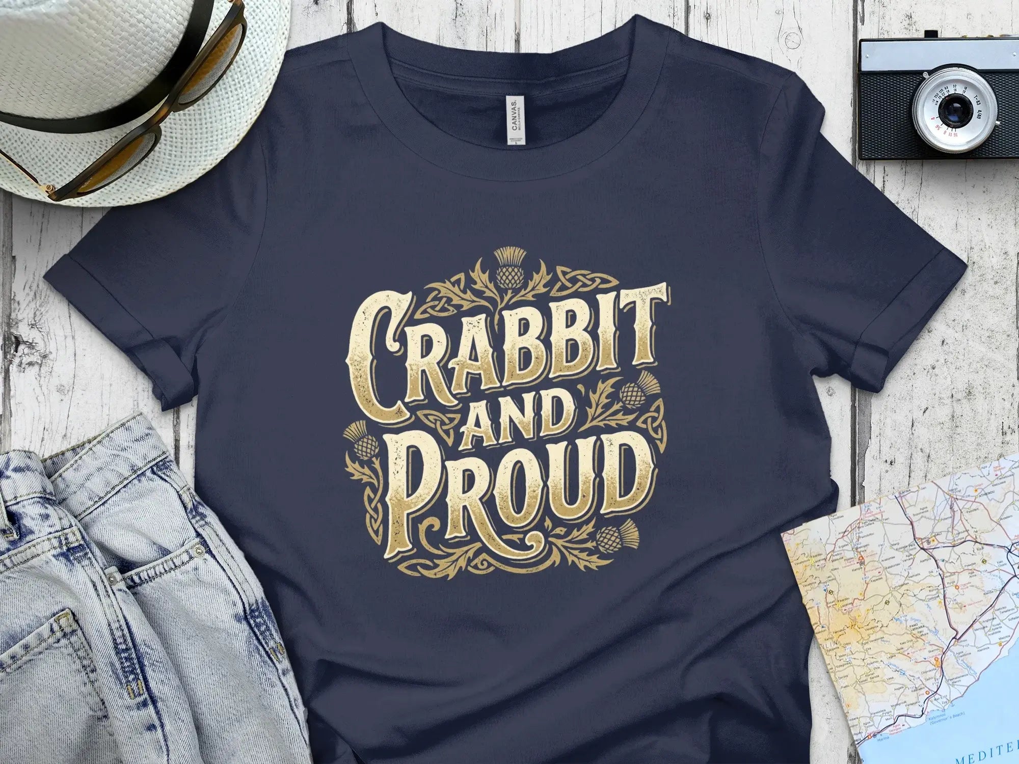 Navy t-shirt with "Crabbit and Proud" text in gold Celtic knot design.