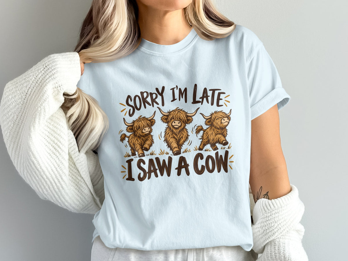 Model wearing the Sorry I'm Late, I Saw a Cow Highland cow Comfort Colors T-shirt in Chambray