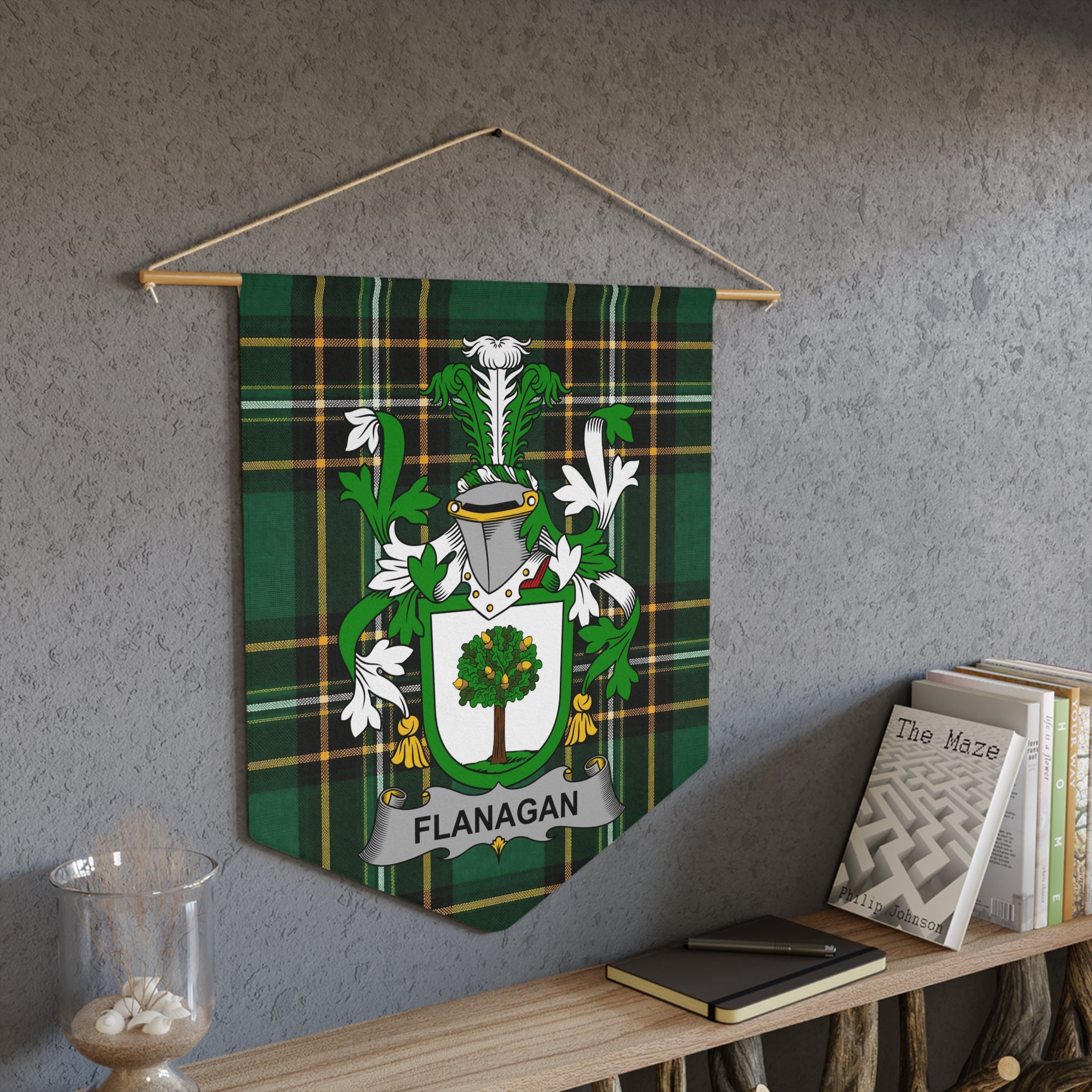 Flanagan coat of arms on green tartan pennant hanging on textured wall.