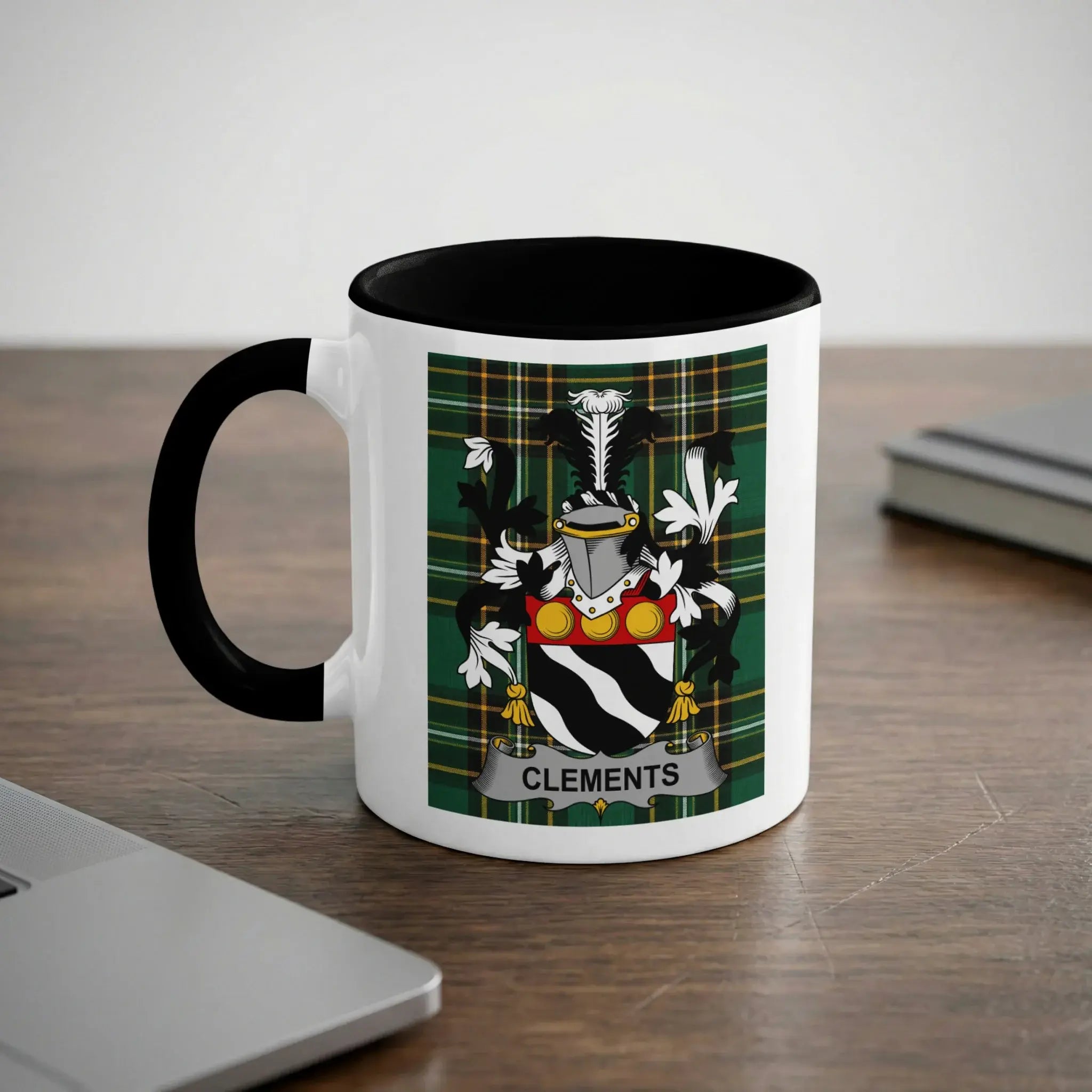 White mug with black rim featuring the Clements family crest and plaid background.