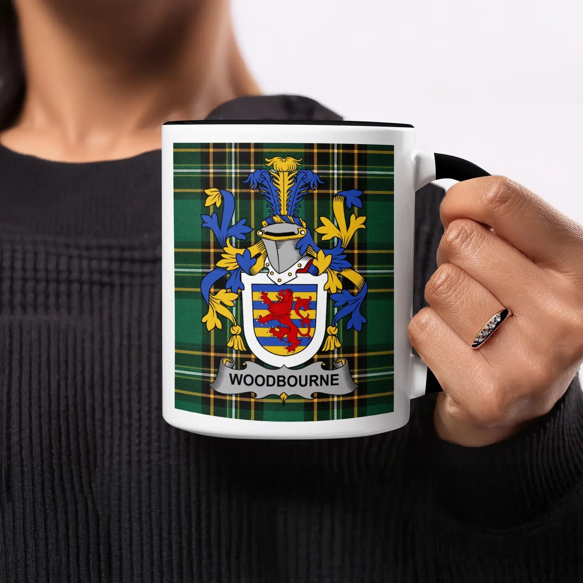 Black mug with Woodbourne family crest on tartan background.