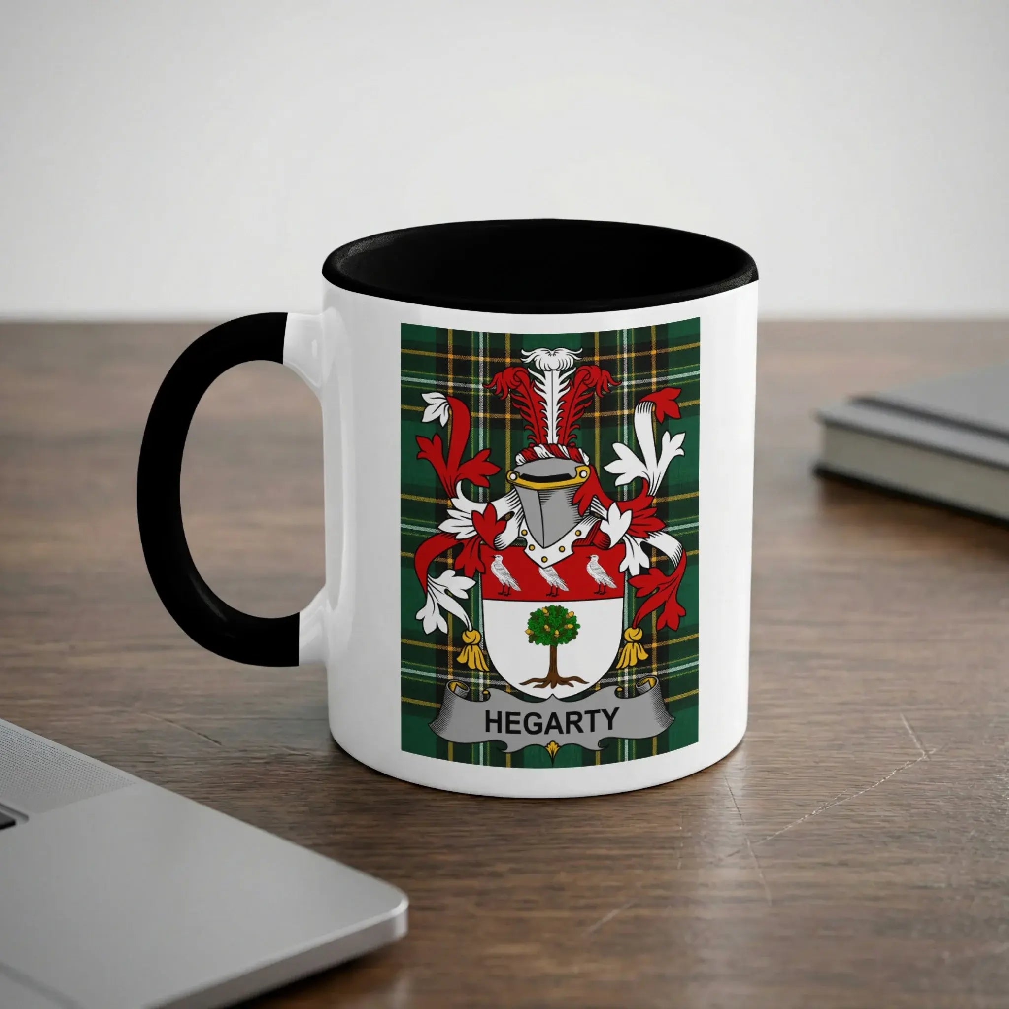 White mug with black rim featuring the Hegarty family crest on a plaid background.