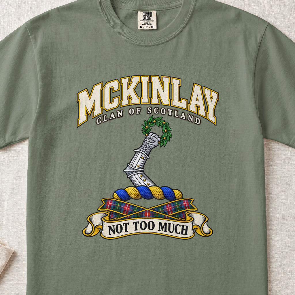McKinlay Scottish clan T-shirt in Moss, front view with an armored arm holding a green leafy wreath and motto banner.