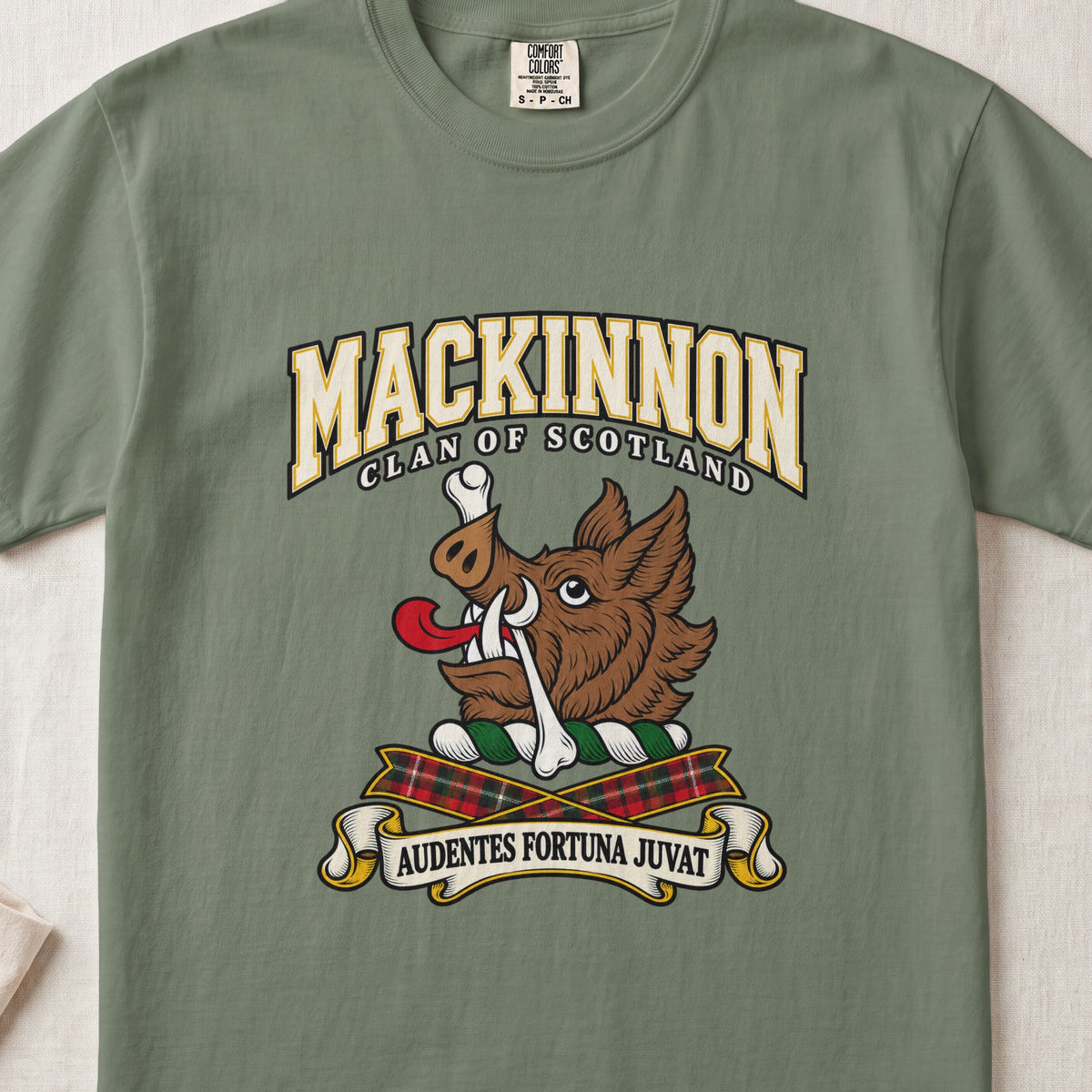 MacKinnon graphic T-shirt in Moss green, front flat lay showing varsity lettering and brown boar head with white tusks, red tongue and a white bone.