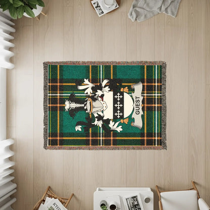 Woven blanket with a green plaid pattern and the Guest family crest.