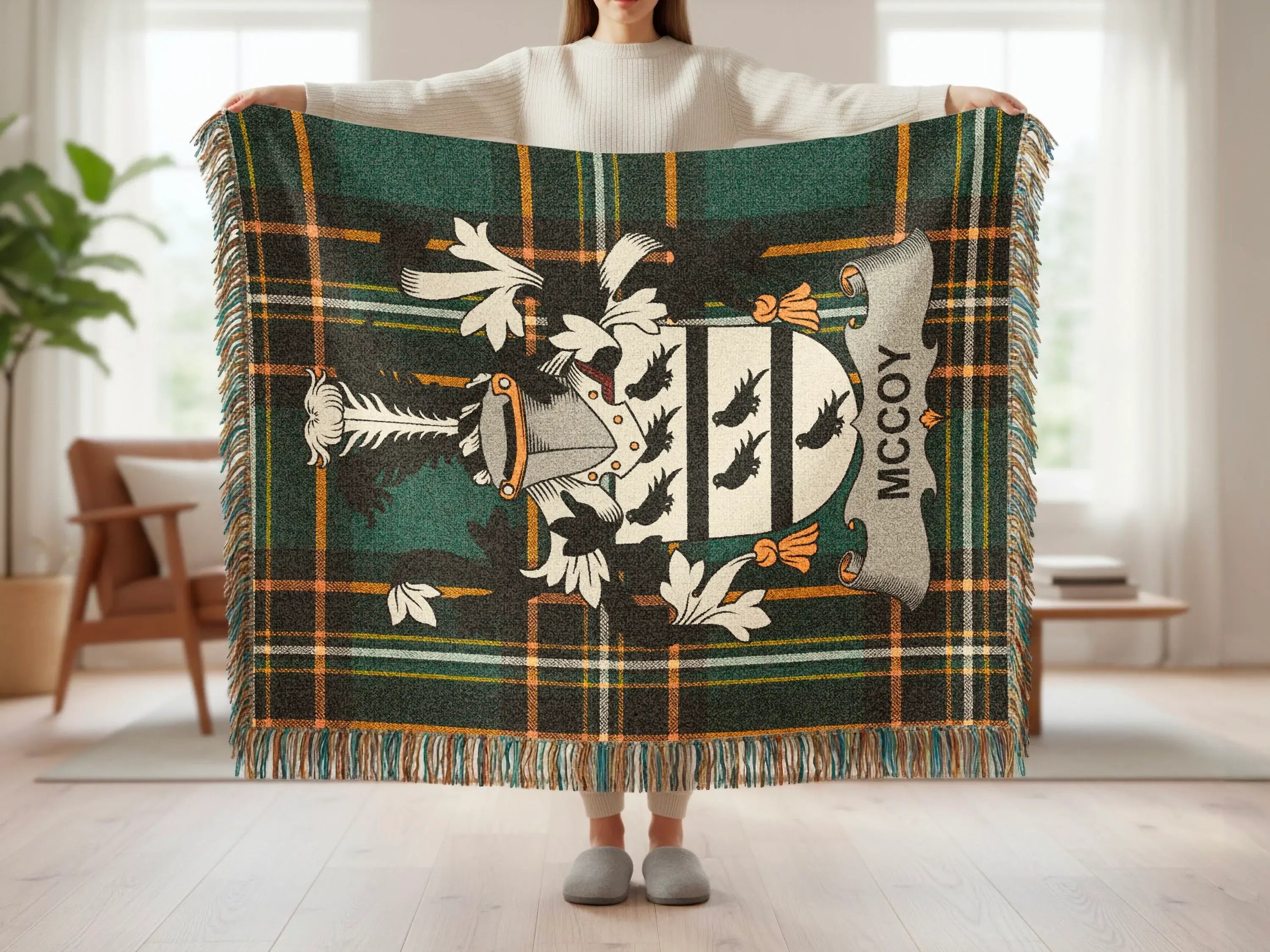 Tartan throw with family crest, "MCCOY" text, and fringed edges.
