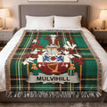 Tartan blanket featuring the Mulvihill family crest on a bed.