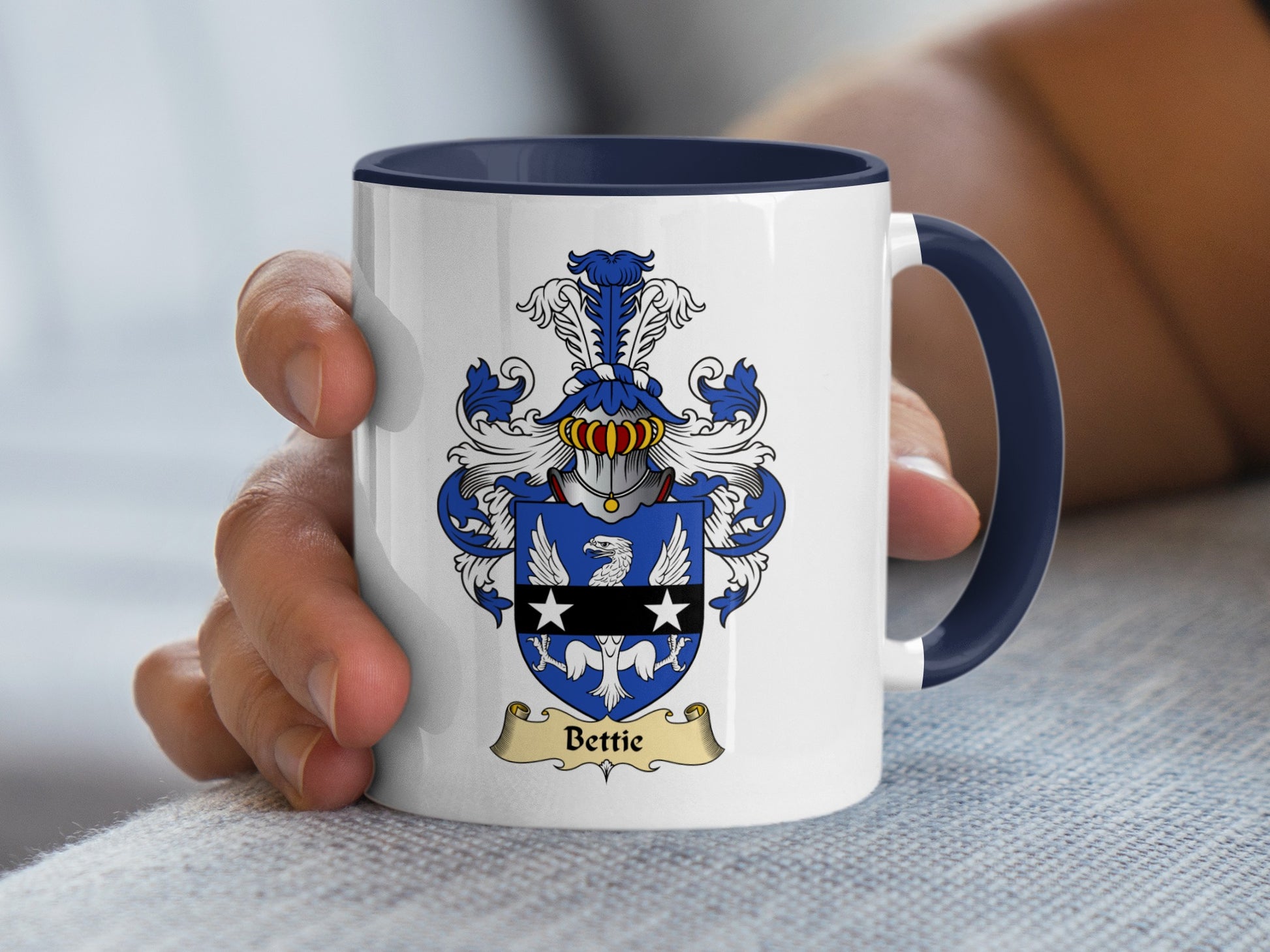 White mug with navy blue handle, displaying a family crest with the name "Bettie".