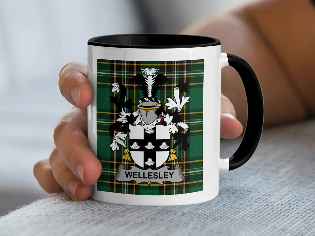 White mug with black rim displaying the Wellesley family crest on a tartan background.