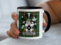 White mug with black rim displaying the Wellesley family crest on a tartan background.