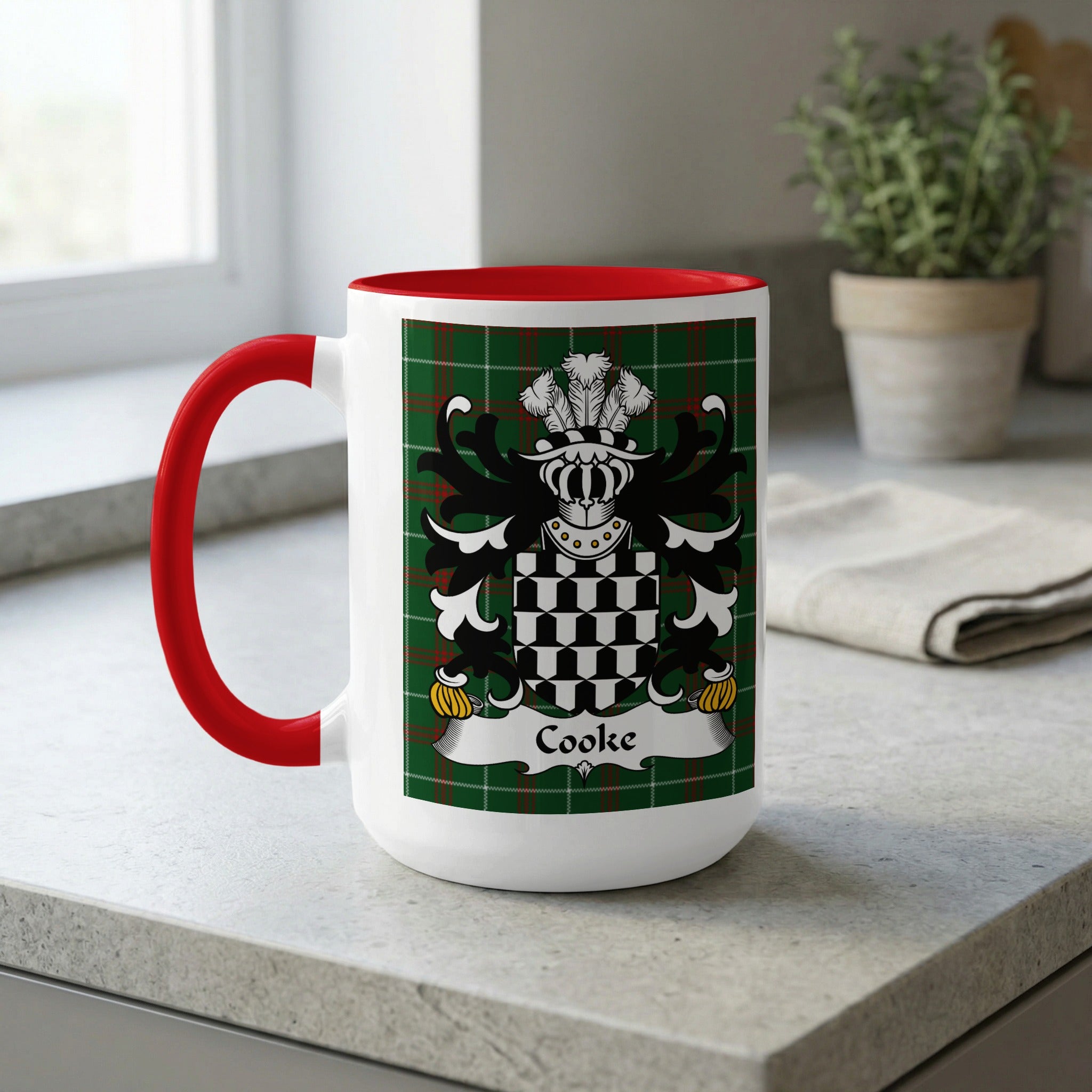 White mug with red handle, displaying a green tartan and the Cooke family crest.