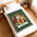 Green tartan blanket with Griffiths family crest on a white bed.