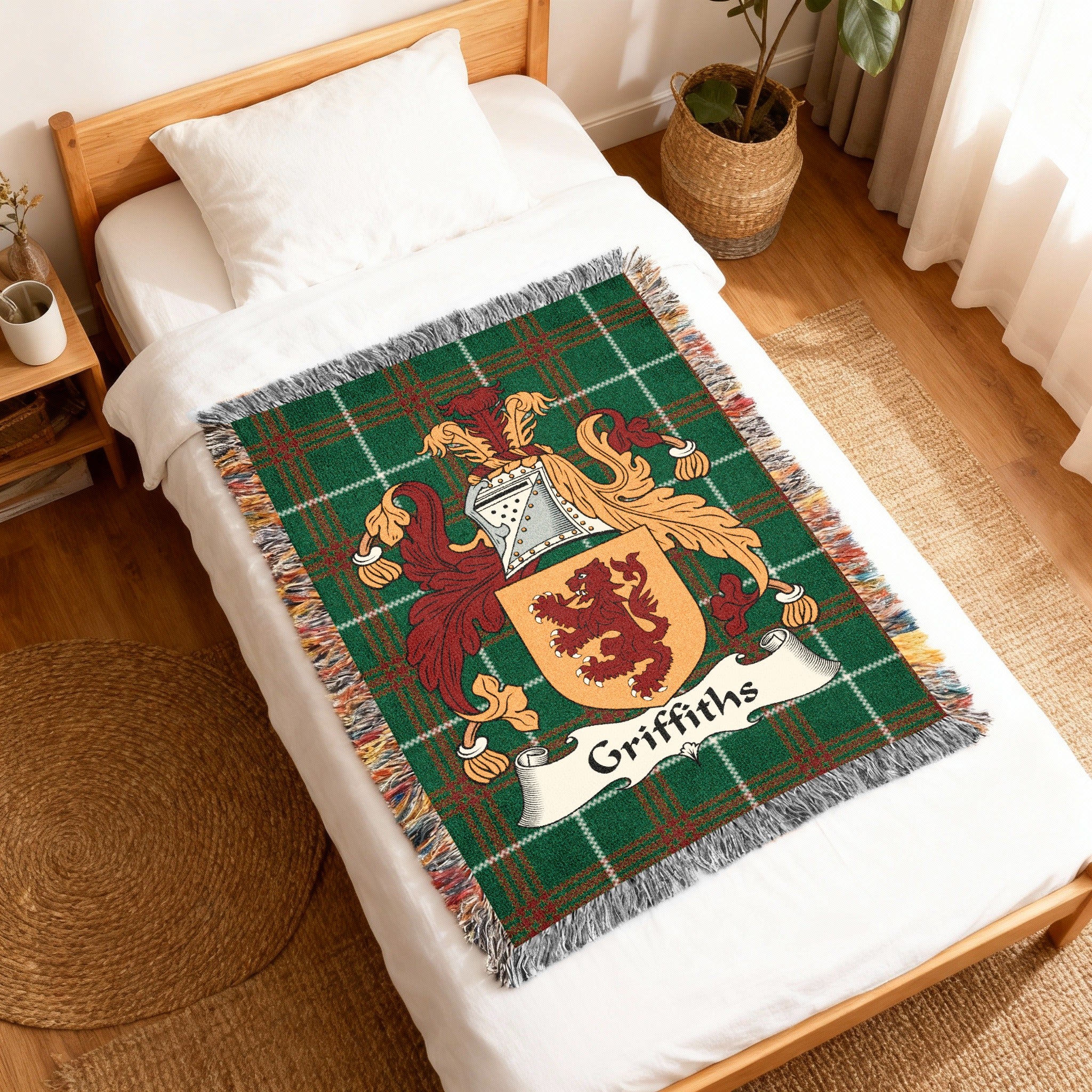Green tartan blanket with Griffiths family crest on a white bed.