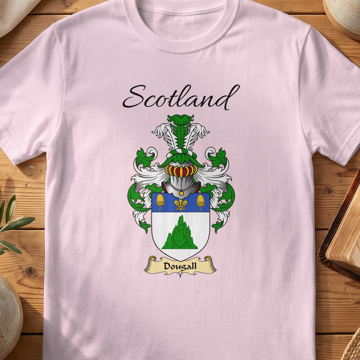Light Pink Dougall Scottish family shield T-shirt featuring a green mound beneath a blue top band
