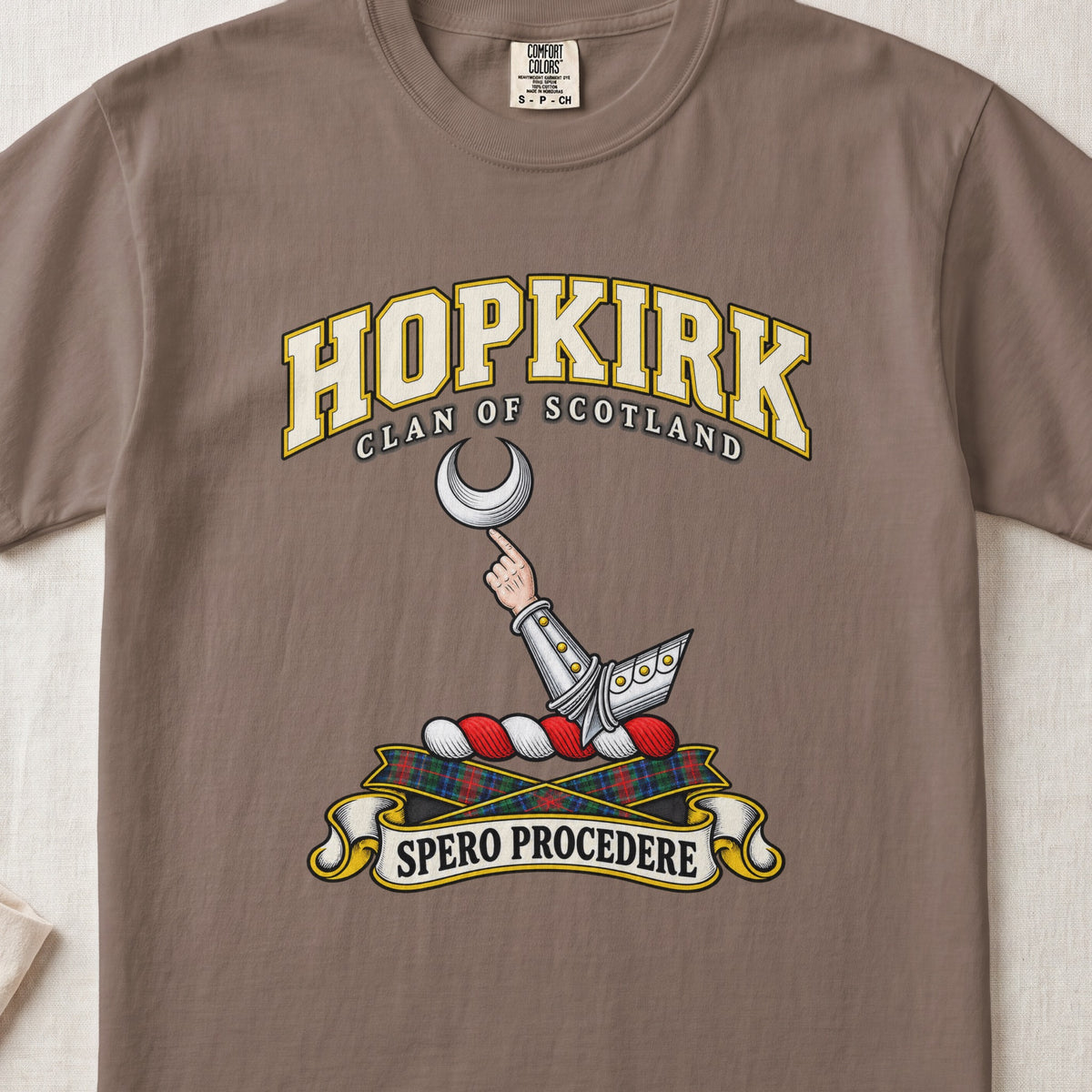 Hopkirk Scottish clan T-shirt in Espresso, front view with an armoured arm holding a silver crescent and motto banner.