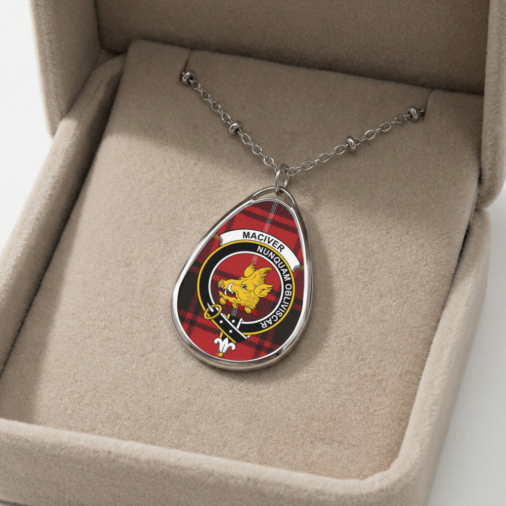 Oval pendant necklace with MacIver clan crest and plaid background inside a velvet box.