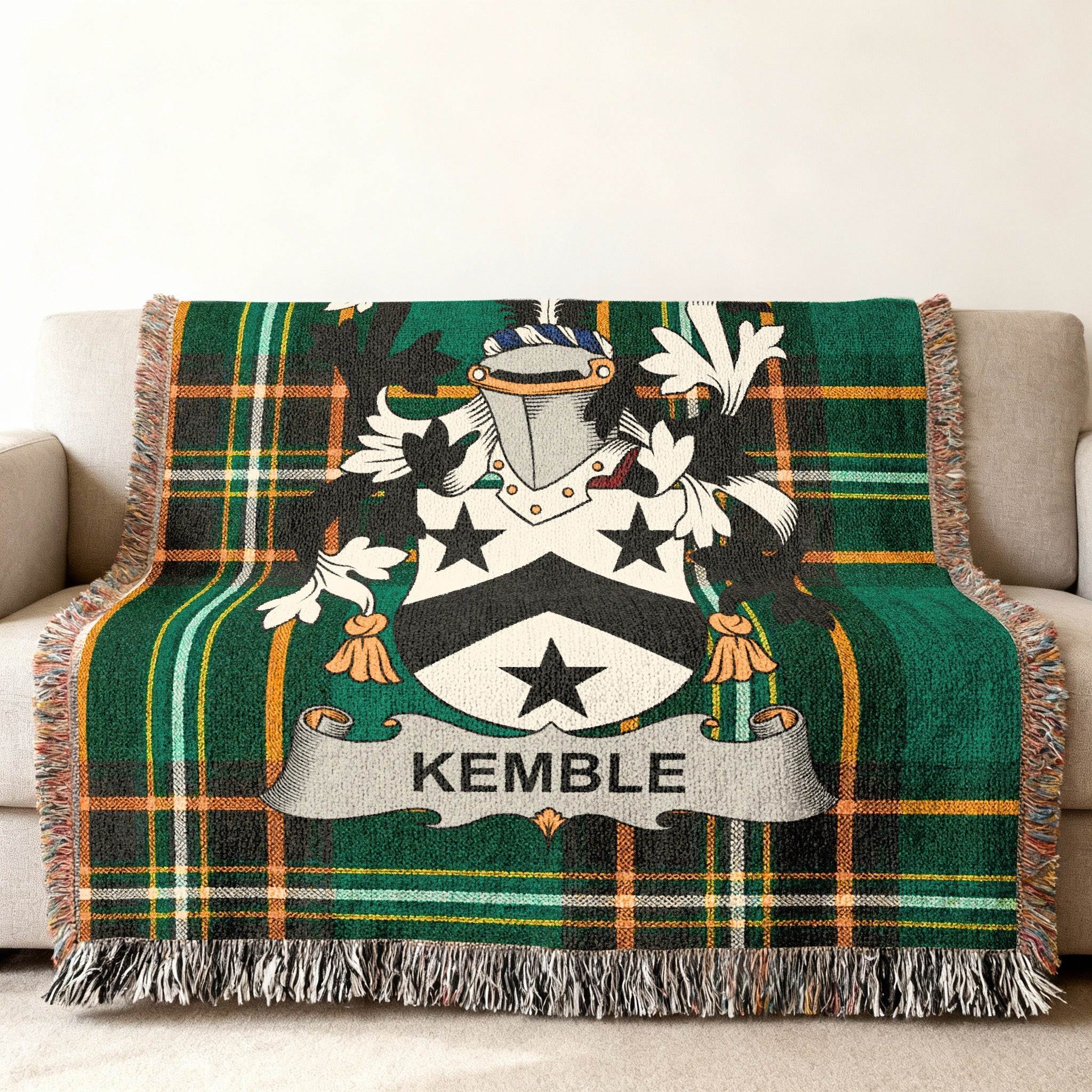Green tartan throw blanket with Kemble family crest on a couch.