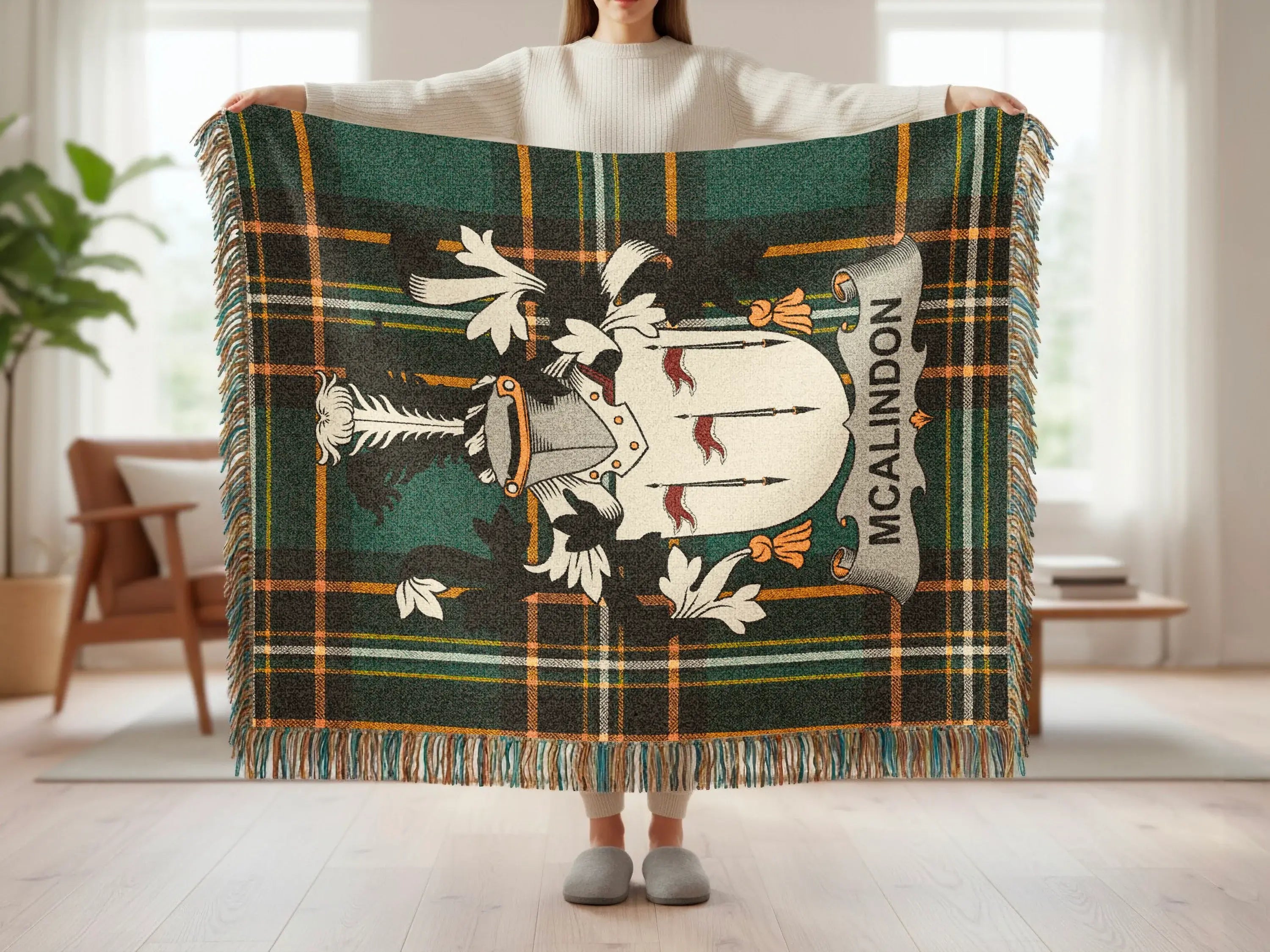 McAlindon tartan blanket with crest, held by a person.