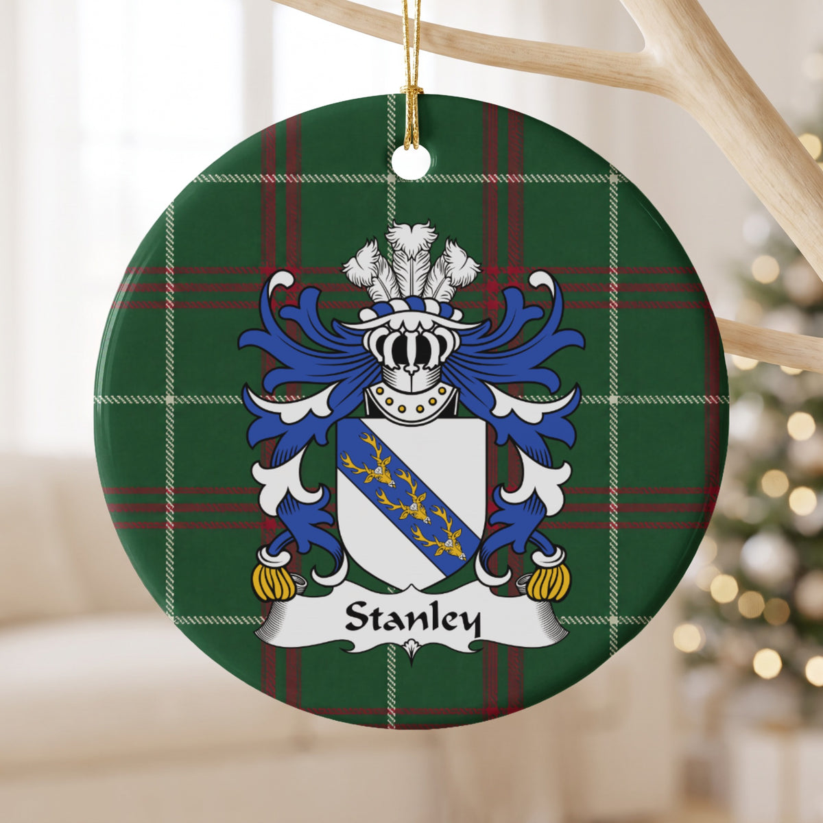 Stanley family crest ornament with Welsh national tartan background, hanging by a gold cord from a wooden display branch.