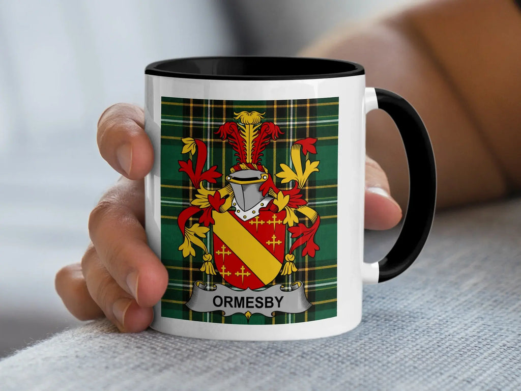 White mug with a coat of arms and "ORMSBY" text held by a hand.