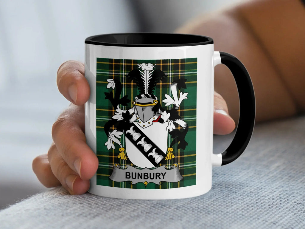 Mug with black handle featuring Bunbury family crest on green tartan.