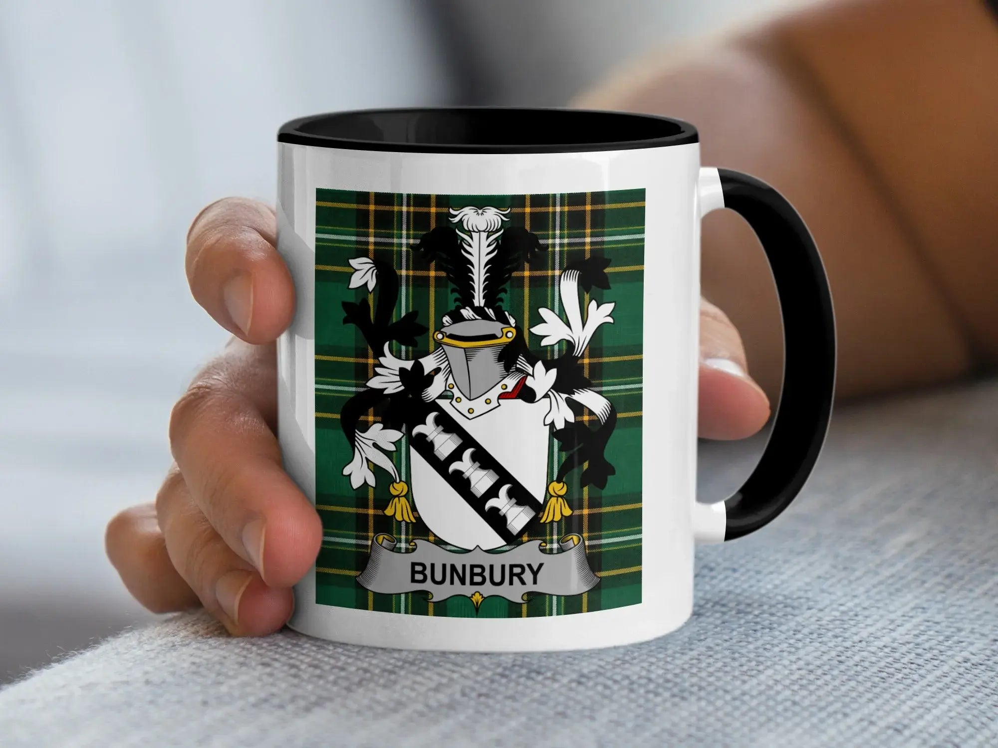 Mug with black handle featuring Bunbury family crest on green tartan.