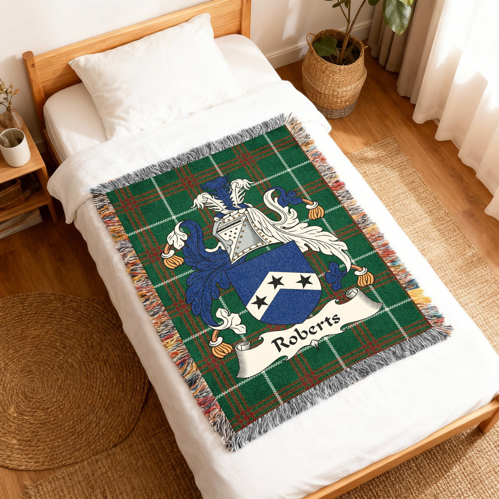 Tapestry blanket with Roberts family crest on a white bed.