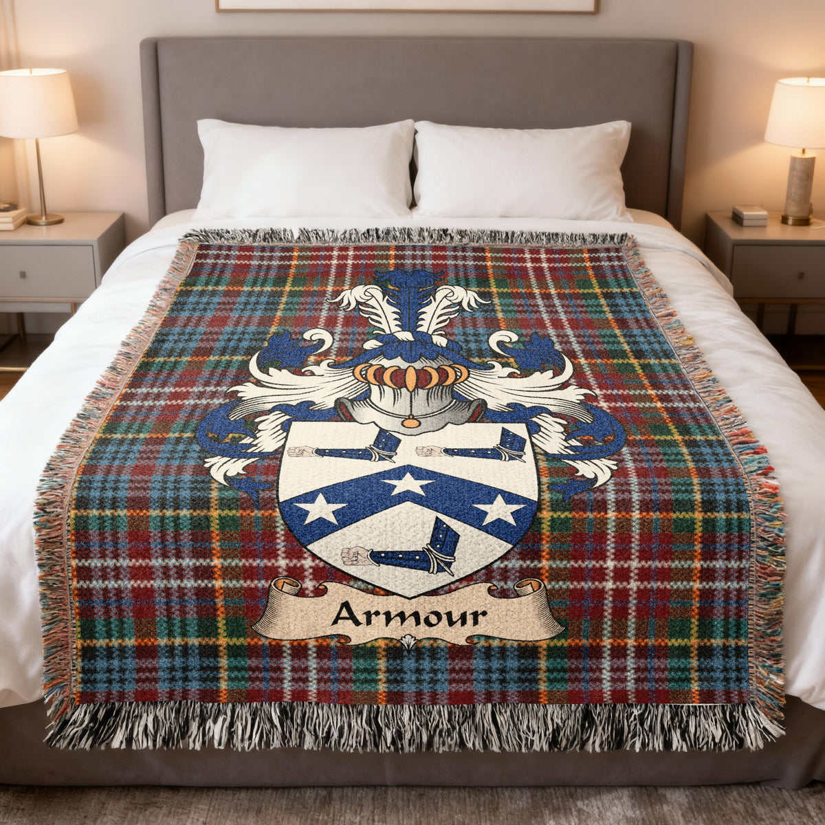 Armour Scottish family crest woven blanket on a Caledonia tartan background, displayed on a bed