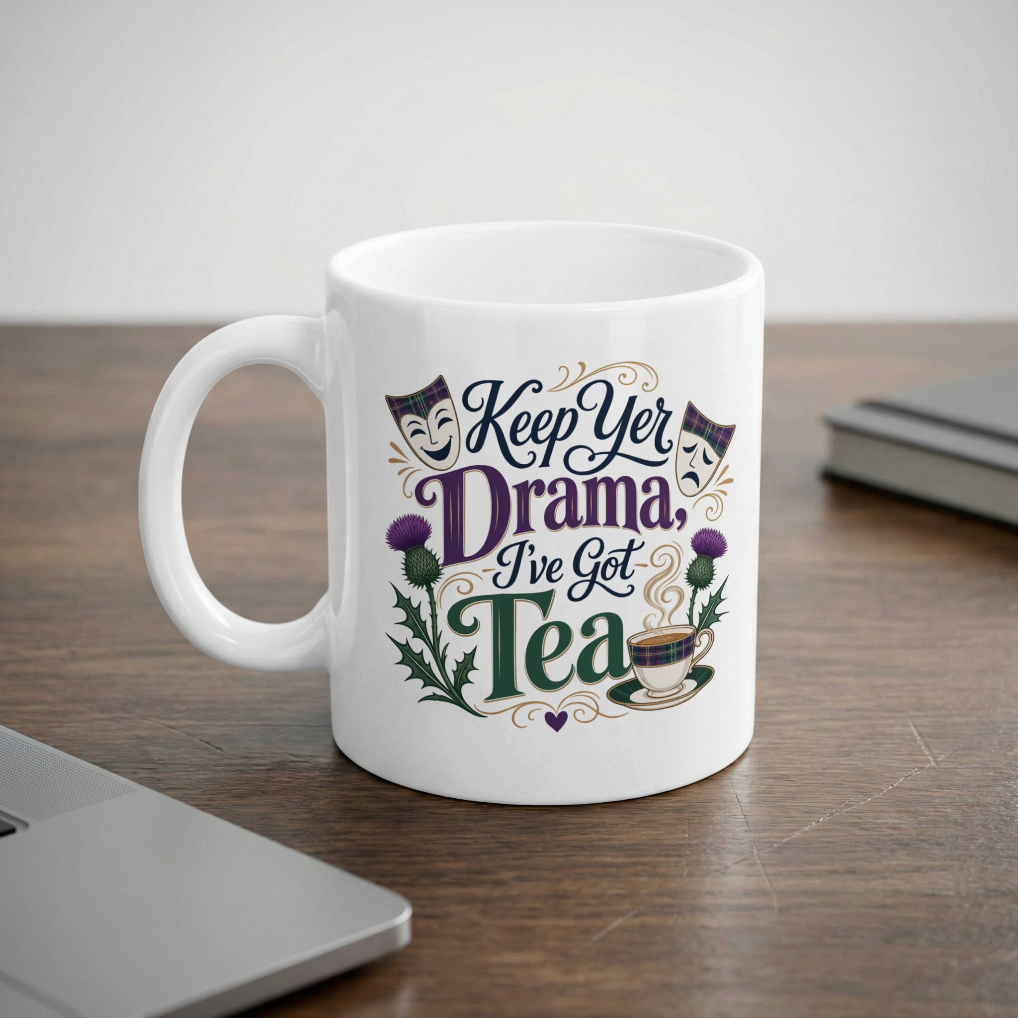 White mug with "Keep Yer Drama, I've Got Tea" design featuring thistles and masks.