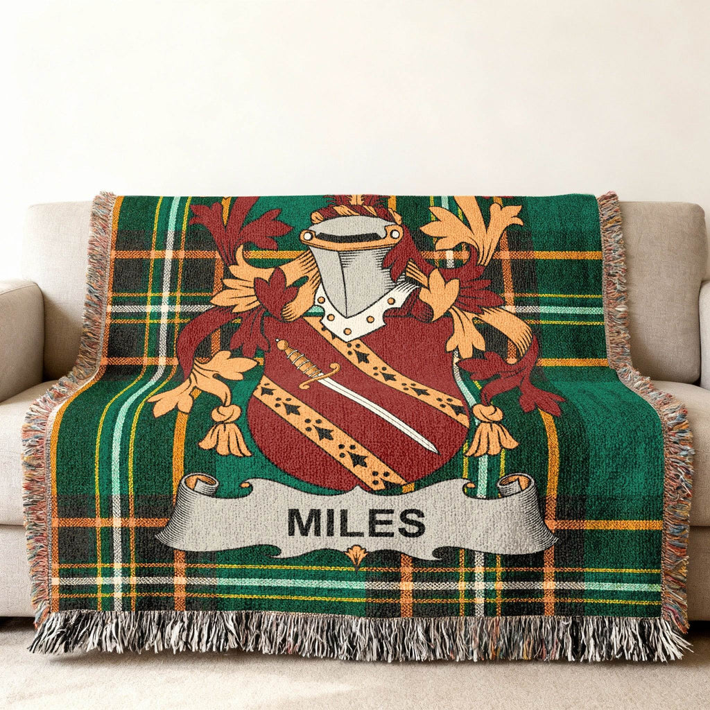 Green tartan throw blanket with Miles family crest and shield.