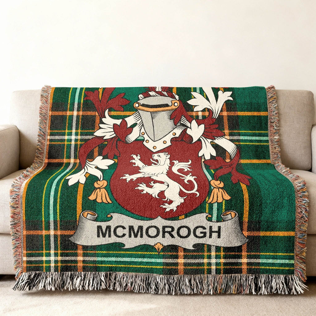 Green plaid blanket with MCMORROUGH family crest draped over a sofa.