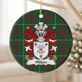 Hilton ornament hanging from a pale wooden branch; a tied bundle of arrows and three black arrowheads on a white shield on Welsh national tartan.