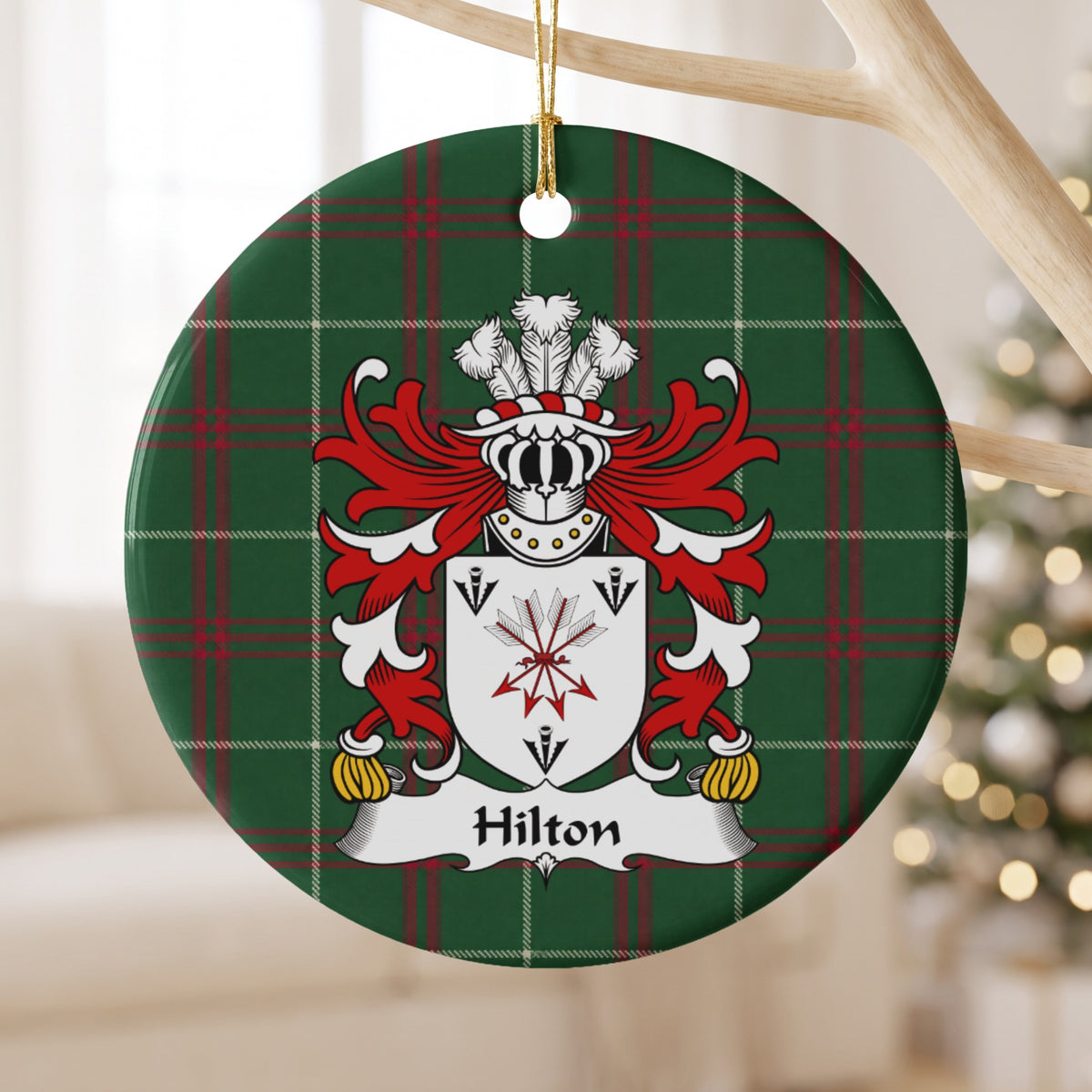 Hilton ornament hanging from a pale wooden branch; a tied bundle of arrows and three black arrowheads on a white shield on Welsh national tartan.