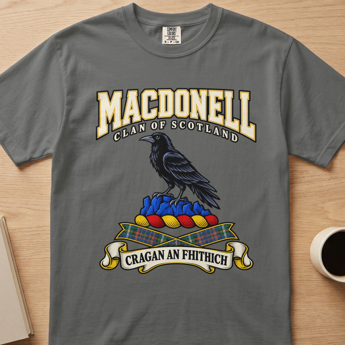 MacDonell dark bird perched on blue rocks graphic on a charcoal gray Comfort Colors T-shirt, front view