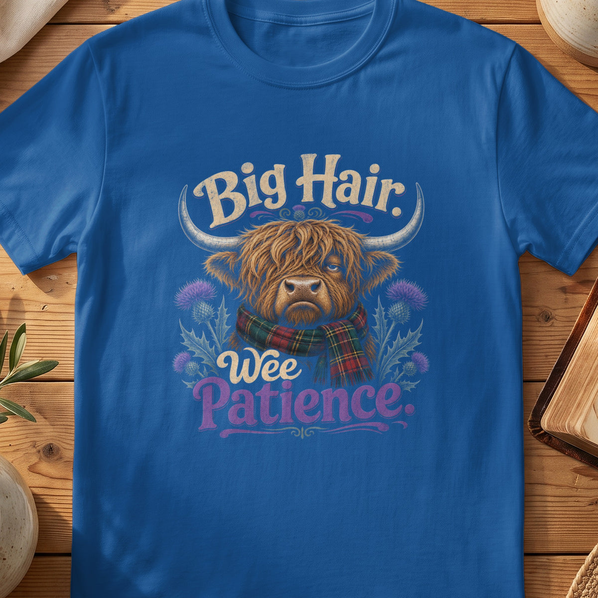 Highland cow graphic with text "Big Hair, Wee Patience" on blue shirt.