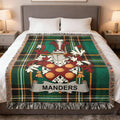Woven tartan blanket with MANDER'S family crest on a bed.